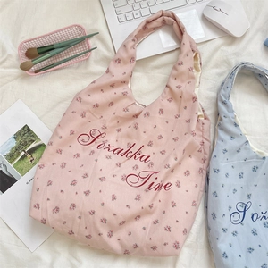 Flache Ansicht von Blumen-Canvas-Taschen mit Sozakka-Schriftzug und Lifestyle-Zubehör