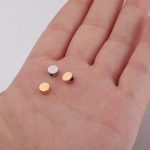 Handheld view of 5mm polished stainless steel beads in silver, gold, and rose gold finishes