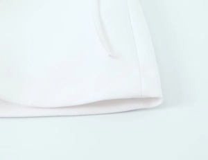 Close-up of white knitted fabric texture with professional precision stitching details