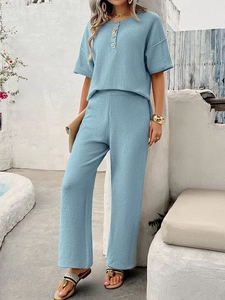 Detail of light blue knitted two-piece set featuring short sleeve top and wide leg pants