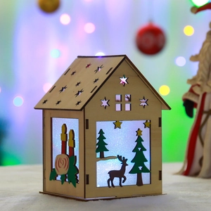 DIY glowing wooden Christmas house ornament with reindeer and tree on white snow background