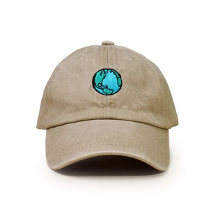 Close-up of earth embroidery on washed khaki cotton baseball cap with stitch detail