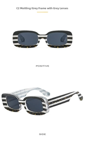Detail view of rectangular sunglasses with striped tortoiseshell frames and grey lenses