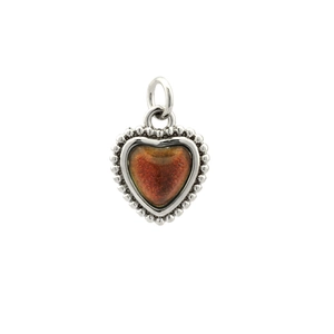 Detail view of heart-shaped pendant with silver frame and reddish-brown textured stone