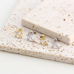 Macro view of gold and silver S925 cross stud earrings with sparkling cubic zirconia