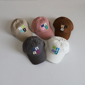 Flat lay of distressed cotton baseball caps with letter embroidery in five colors