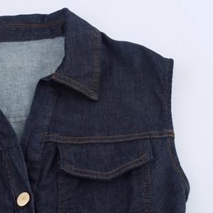 Détails de la robe en jean bleu foncé avec bouton doré et coutures orange apparentes
