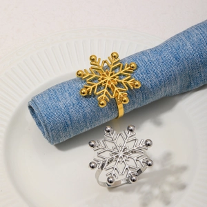 Detail of gold and silver snowflake napkin rings with rhinestones on a blue linen napkin