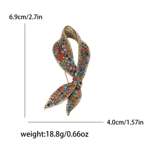 Luxurious vintage ribbon bow brooch in bronze finish with colorful rhinestones on white background