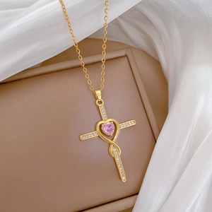 Luxurious gold cross necklace with pink heart gemstone and crystals on elegant jewelry box