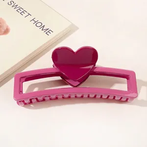 Close-up of a pink heart claw clip showing the glossy plastic texture and sturdy teeth