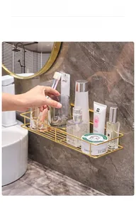 Close-up of golden iron bathroom shelf showing drainage grid on marble wall