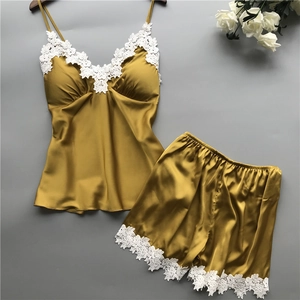Detail of mustard gold satin pajama set with intricate white floral lace trim on V-neck