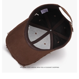 Detail of dark brown baseball cap showing internal washing label and metal buckle closure