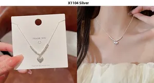 Detail of silver heart pendant necklace showing fine bead chain and fit on model neck