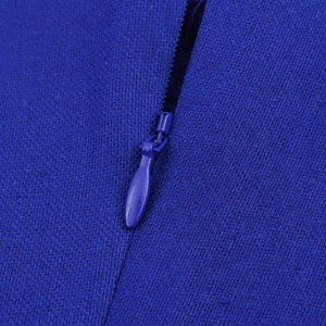 Macro shot of invisible blue zipper and woven fabric texture on a long dress