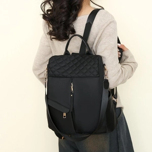Women's black nylon backpack with quilted diamond stitching and gold-tone zippers