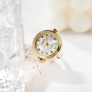 Exquisite gold ring watch with colorful rhinestone dial on elegant marble display stone