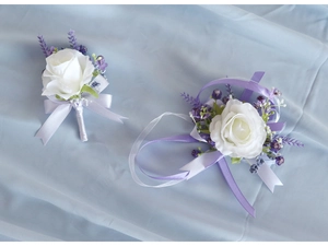 Detailed view of white rose and lavender boutonniere with matching wrist corsage set