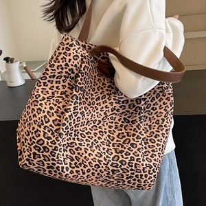 Grand sac cabas en toile à imprimé léopard avec bretelles marron porté à l'épaule