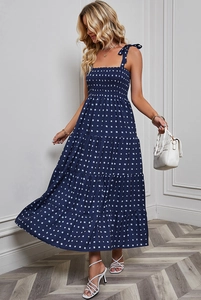 Detail of dark blue backless floral maxi dress with white square print and layered hemline