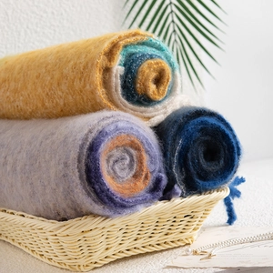 Soft checkered mohair scarves in yellow, purple, and blue colors in a woven basket