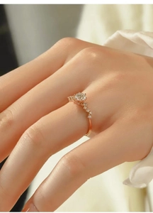 Close-up of a rose gold ring with a sparkling moissanite stone on a model hand