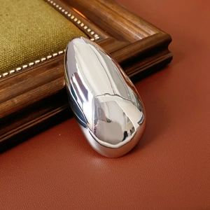Macro shot of silver irregular oval brooch on leather with reflective mirror finish