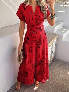 Detail view of red V-neck wide leg jumpsuit with black abstract prints and waist belt