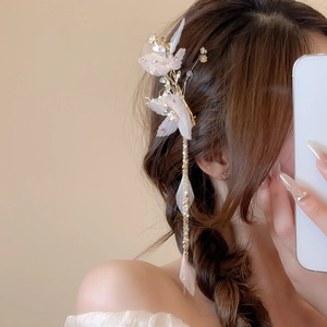 Détail de la pince à fleurs aux pétales roses, perles et longues franges