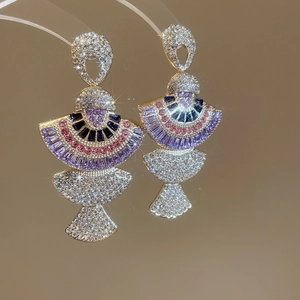 Macro shot of luxury fan-shaped earrings with colorful rhinestones and gold metal base