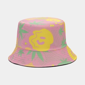 Close-up of pink bucket hat featuring green leaves and yellow smiley face patterns