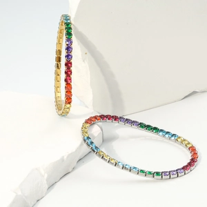 Détail de bracelets tennis en or et argent avec des pierres arc-en-ciel en dégradé