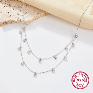 Double-layered 925 sterling silver necklace with sparkling zircon stones on white surface