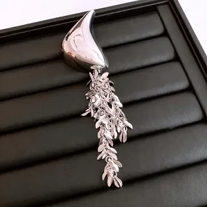 Minimalist geometric tassel brooch in polished silver metal with sleek long leaf design