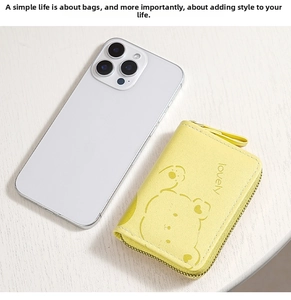 Compact yellow zip wallet with bear print shown next to a smartphone for size scale