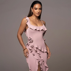Detailed view of pink backless midi dress featuring ruffle trim and a large fabric flower