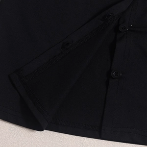 Detail of black knit long sleeve top with matching buttons and smooth stitching