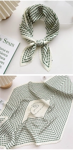Detail of pleated silk scarf with emerald stripes and artistic face line drawing