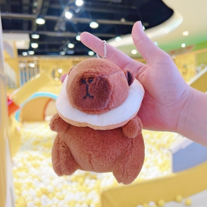 Close-up of plush brown Capybara keychain with a white scarf and metal bead chain