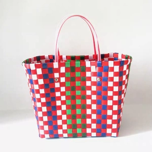 Handwoven colorful checkered plastic tote bag with double translucent handles and metal rivets