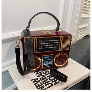 Detailed close-up of dark burgundy acrylic radio shaped handbag with vintage tuner panel