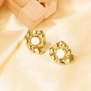 Dettaglio degli orecchini in metallo strutturato placcato oro 18k con smalto bianco