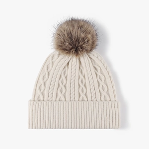 Berretto in maglia crema con motivo a trecce e un grande pompon in pelliccia marrone