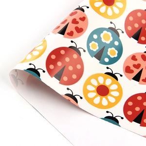 Cartoon ladybug pattern wrapping paper with colorful heart and flower design details