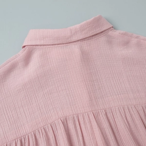 Detail view of pink shirt with lapel collar and pleated back yoke texture