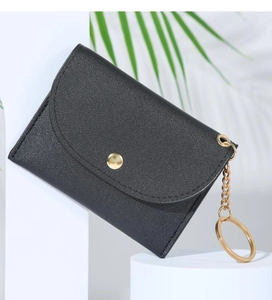 Close-up of compact black PU leather coin purse with gold button and keychain chain