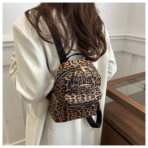 Mini leopard print backpack shown on a model with fine canvas texture and gold zippers