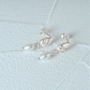 Macro detail of S925 silver pearl drop earrings with sparkling micro-pave crystals