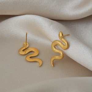 Détail de boucles d'oreilles serpent en acier plaqué or 18K avec motif d'écailles